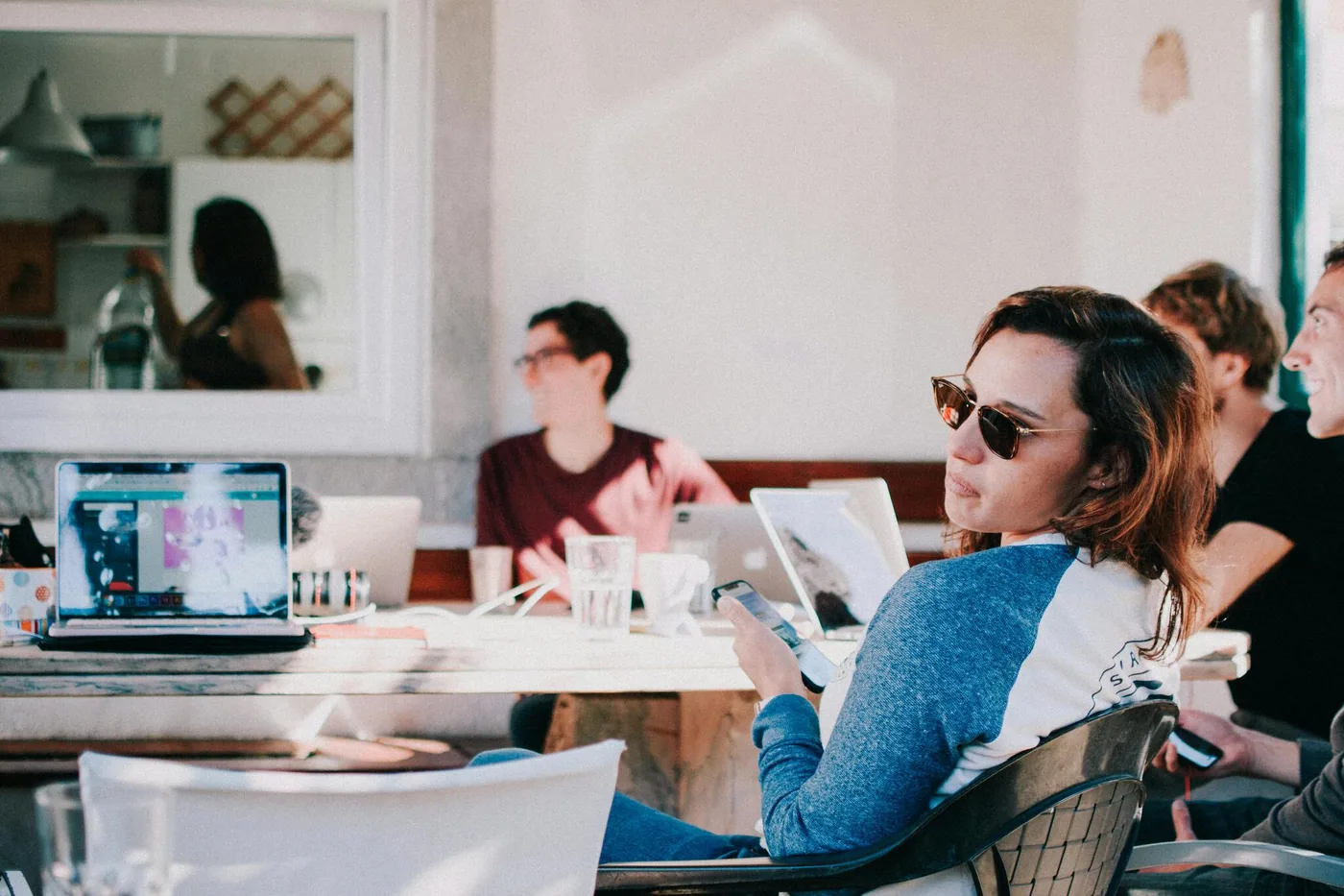 Young adults working on laptops and smartphones in a relaxed co-working space